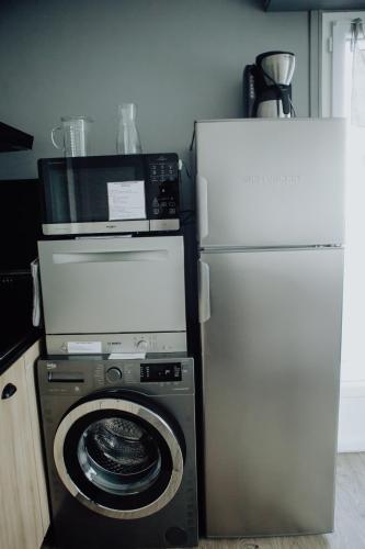 a refrigerator and a washing machine and a microwave at Les Terrasses sur Seine in Vernon