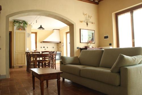 Podere la Campagnola في سان جيمنيانو: غرفة معيشة مع أريكة وطاولة ومطبخ