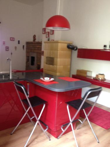 a red kitchen with a red table and chairs at Appartement am Tegeler See in Berlin