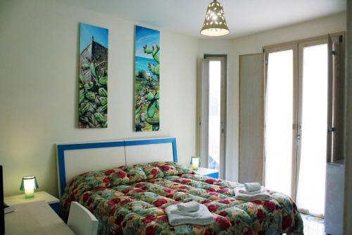 オートラントにあるCamere Borgoのベッドルーム1室(ベッド1台付)が備わります。壁には絵画2点が飾られています。
