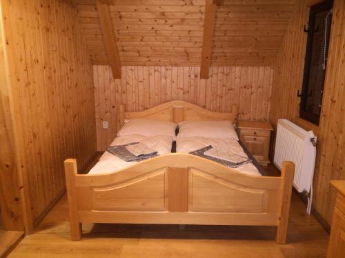ein Schlafzimmer mit einem Bett in einer Holzhütte in der Unterkunft Chata Sofia Námestovo in Námestovo