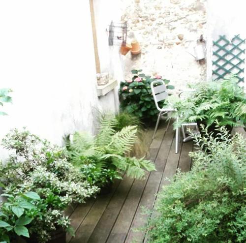 a patio with a table and chairs and plants at Chambre d'hôte du Château in Dourdan