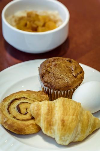 a white plate with a muffin and a cup of soup at Monte Carlo Inn & Suites Downtown Markham in Markham