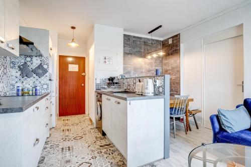 une cuisine avec des placards blancs et une chaise bleue dans l'établissement Appart pour 4 - Plage à 250m à St Jean de Monts, à Saint-Jean-de-Monts