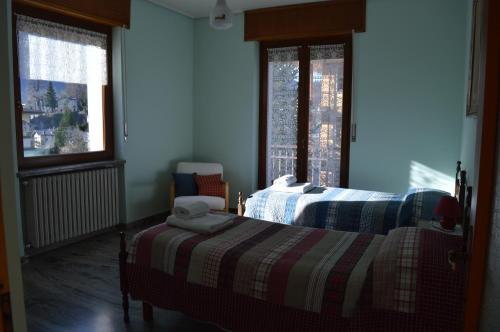 a bedroom with two beds and two windows at Cà di Candi in Demonte