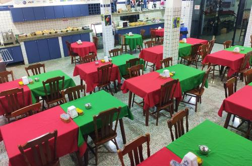 an empty dining room with red and green tables at LM Hotel in Sao Paulo