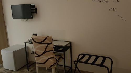 een kamer met een stoel, een tafel en een tv bij THAT'S AMORE FIUMICINO Airport in Fiumicino