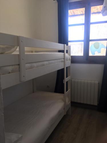 two bunk beds in a room with a window at La Cobacha in Cazalla de la Sierra