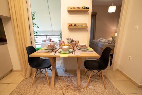 a wooden table with black chairs in a room at Boheme and Style in Preveza