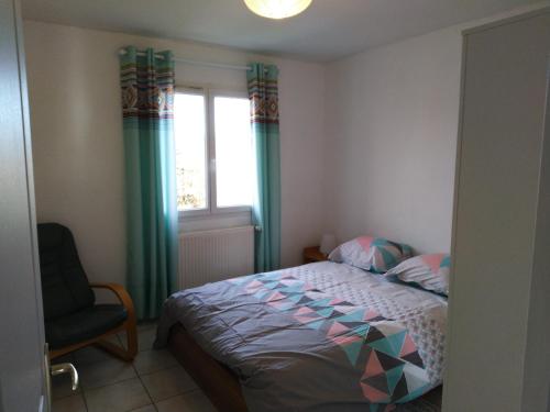 een slaapkamer met een bed, een stoel en een raam bij logis SAINT AUSTREMOINE in Issoire