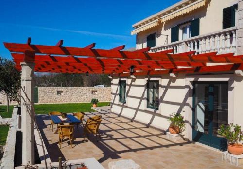 Villa Antonija في سيليبي: فناء فيه بريغولا احمر مقابل منزل