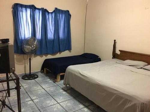 una camera con letto, ventilatore e finestra di Casa 4-100-egas a Cuatrociénegas de Carranza