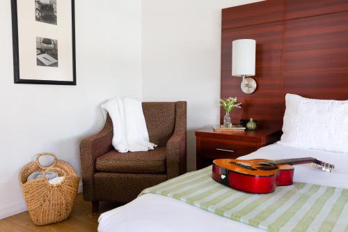 a hotel room with a guitar and a chair at Diablo Mountain Inn Walnut Creek in Walnut Creek