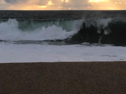 a large wave in the ocean with a beach at L'Escale au Portugal Villa-B&B-Spa in Ataíja de Baixo
