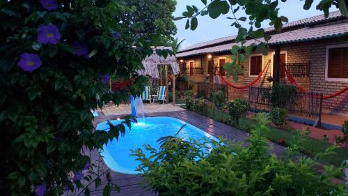 a swimming pool in front of a house at Pousada Brasil in São Miguel do Gostoso