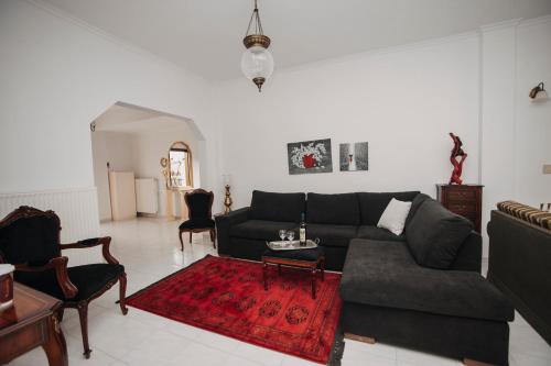 a living room with a couch and a red rug at Mythic House in Leptokaria