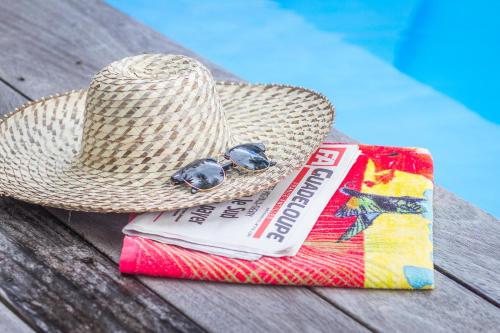 a straw hat and a book on a picnic table at L'Îlot Palmiers in Pointe-Noire