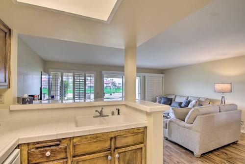 uma cozinha com um lavatório e uma sala de estar em Palm Royale CC Apt with Golf Course and Mtn Views! em La Quinta