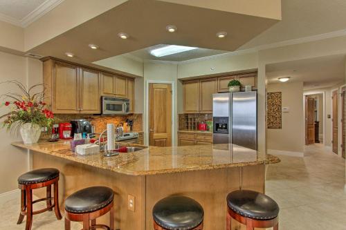 a kitchen with a large island with bar stools at Ornate Resort Condo with Balcony, Pool, Water Views! in Pensacola