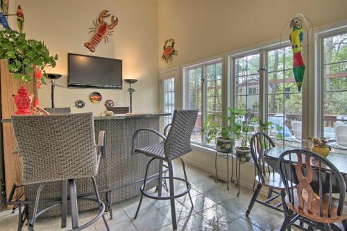 a dining room with a table and chairs and windows at 2 Mi to Golf Retreat with Hot Tub in Ocean Pines in Ocean Pines