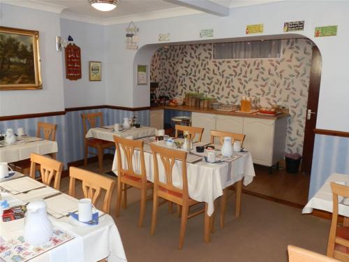 a dining room with tables and chairs in a restaurant at Clarence House in Skegness
