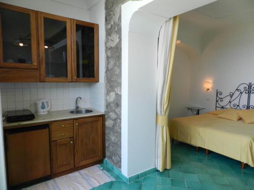 a bedroom with a white bed and white walls at Bacio del Sole B&B Positano in Positano