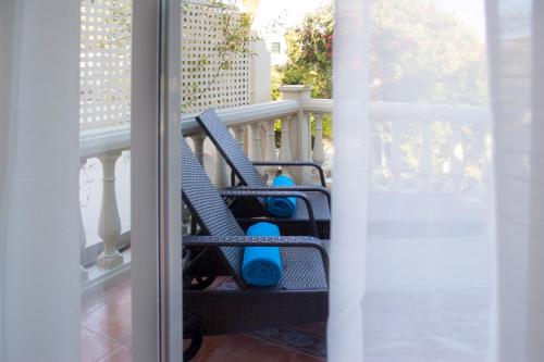 a balcony with two blue chairs on a porch at Villa de Lujo con Jardines y Piscina in El Puerto de Santa María