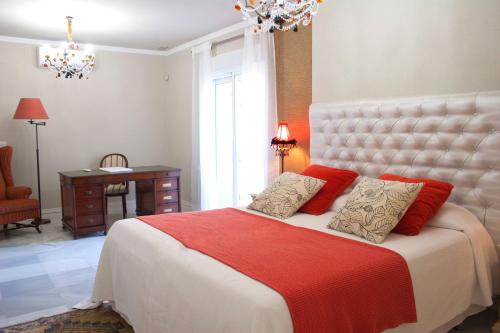 a bedroom with a large bed with red pillows at Villa de Lujo con Jardines y Piscina in El Puerto de Santa María