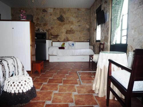 1 dormitorio con cama y pared de piedra en Casa da Gándara Apartamento en Boimorto