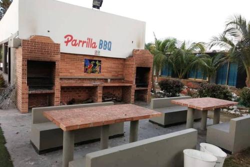 two picnic tables in front of a brick building at Apartamento en Coveñas cómodo y acogedor in Coveñas