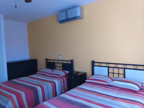 - 2 lits installés l'un à côté de l'autre dans une chambre dans l'établissement Depto Las Puertas la Ria #5, à Campeche