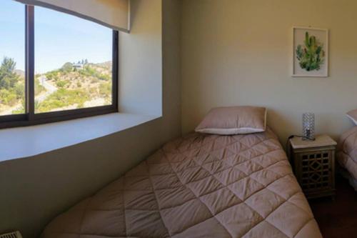 um quarto com uma cama e uma janela em Espectacular Departamento Marina Golf Rapel em Las Cabras