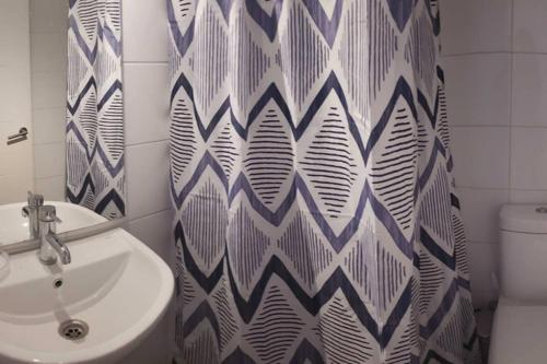 a bathroom with a sink and a shower curtain at Espectacular Departamento Marina Golf Rapel in Las Cabras