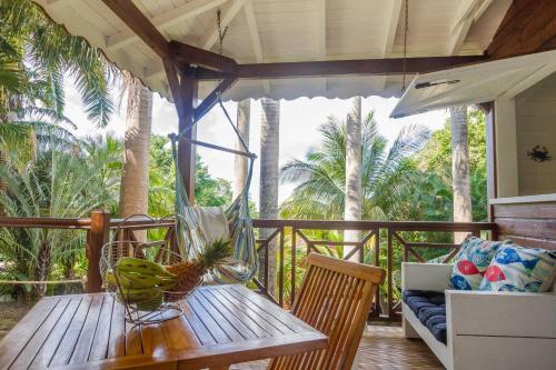 a wooden table with a bowl of bananas on a porch at L'Îlot Palmiers in Pointe-Noire
