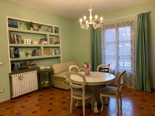 - un salon avec une table, des chaises et un canapé dans l'établissement A casa di Sara, à Comano