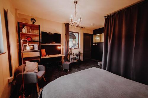 GesvesにあるAt Home - Jacuzzi privatifのベッドルーム1室(ベッド1台、椅子、デスク付)