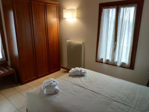 a bedroom with a bed with towels on it at La Rotonda Relais in Badoere