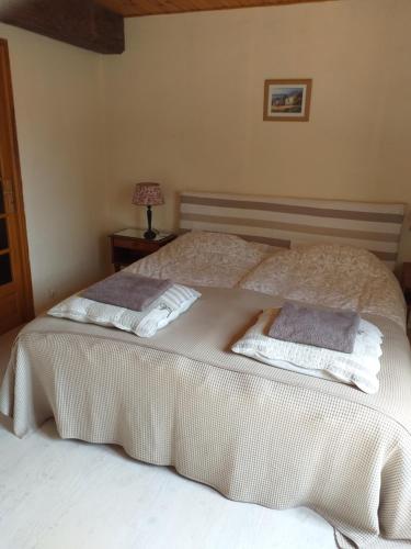ein Schlafzimmer mit einem Bett mit zwei Handtüchern darauf in der Unterkunft Gîte Moulin de Ludièras in Busserolles