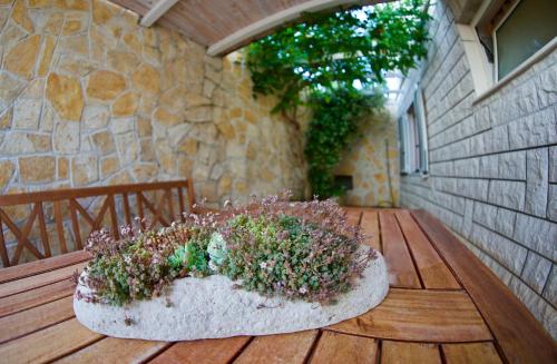 a planter with flowers on a wooden deck at Bed and Breakfast BLUE in BLUE in Komiža