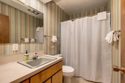 een badkamer met een wit douchegordijn en een wastafel bij Pacific Sands Resort in Neskowin