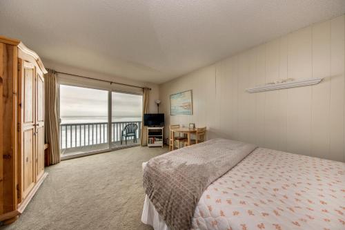 een slaapkamer met een bed en uitzicht op de oceaan bij Pacific Sands Resort in Neskowin