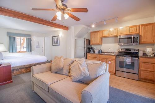 uma sala de estar com um sofá e uma cozinha com uma cama em Murphy's River Lodge em Estes Park