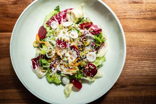 a salad on a white plate on a wooden table at Hotel Bijou - Union Square in San Francisco