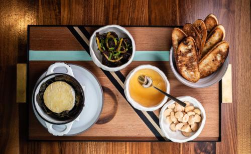 a wooden table topped with plates of food and bread at Hotel Bijou - Union Square in San Francisco
