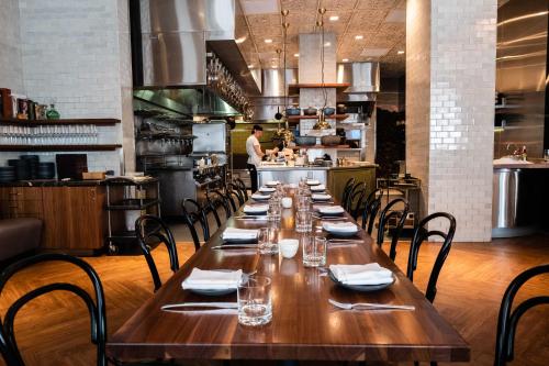 a long table in a restaurant with a chef in the kitchen at Hotel Bijou - Union Square in San Francisco