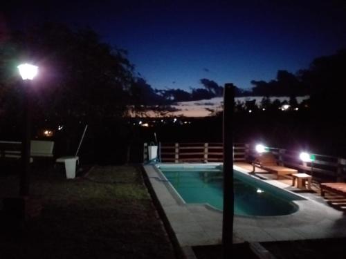 ein Schwimmbad in der Nacht mit Straßenbeleuchtung in der Unterkunft Casa en Balcón de Mallín, Mirador del Lago in Bialet Massé