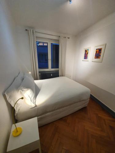 a bedroom with a white bed and a window at Appartement Strasbourg Cathédrale in Strasbourg