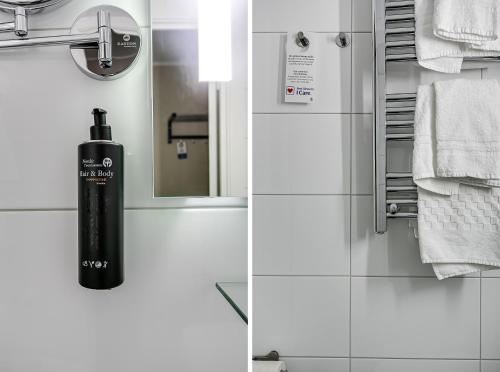 a bathroom with a black soap dispenser next to a mirror at Best Western Hotel Savoy in Karlstad