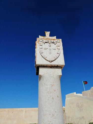 a stone pillar with a clock on top of a building at The Portuguese Element in Faro