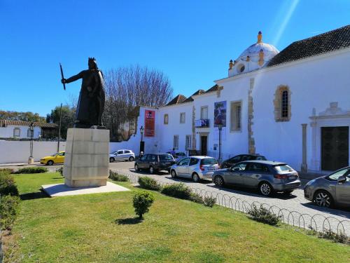 a statue of a man standing next to a building at The Portuguese Element in Faro